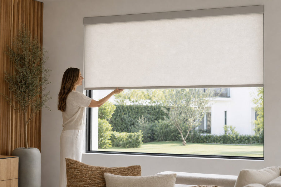 Hand lowering a cordless roller shade by its bottom bar