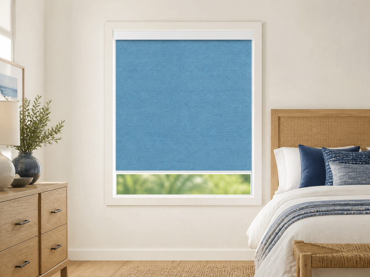 Azure matte blackout roller shade in a coastal blue guest bedroom